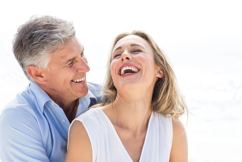 An image of dental implant patients smiling.