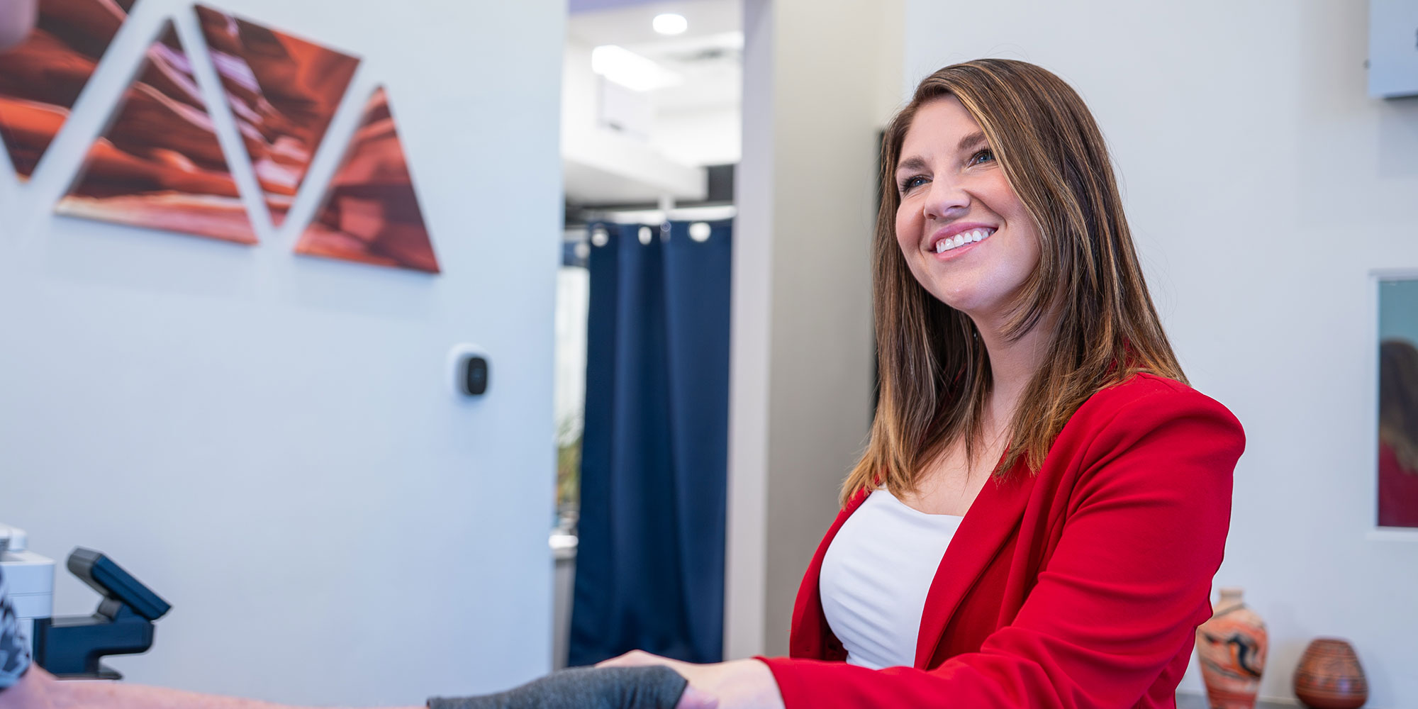 coordinator in red welcoming patient